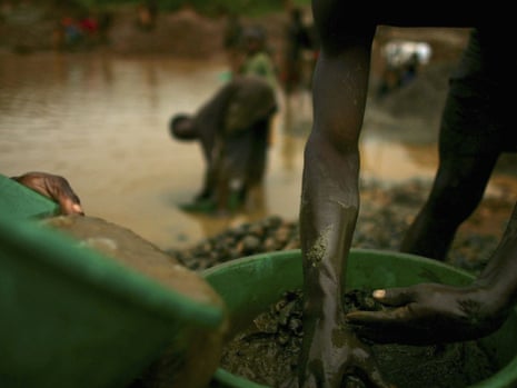 Sifting through buckets of dirt looking for gold in Mongbwalu, DRC