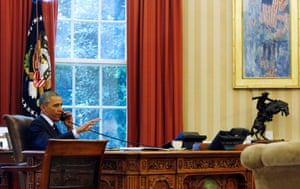 U.S. President Barack Obama is photographed through the window as he speaks in the Oval Office during a conference call hosted by the American Lung Association to find ways to reduce carbon pollution from power plants at the White House in Washington, June 2, 2014.
