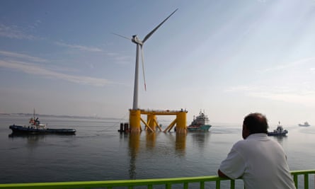 A ferry sailor watches the windmill, Wind Float I, at the Setubal city bay, 50 km (31 miles) south of Lisbon