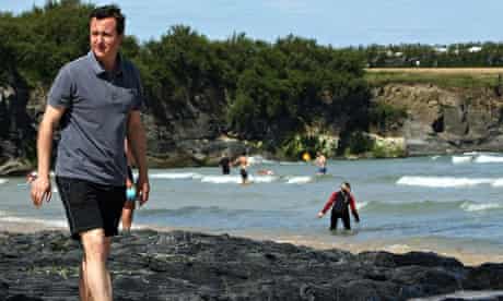 David Cameron in shorts and a polo shirt on the beach in Cornwall