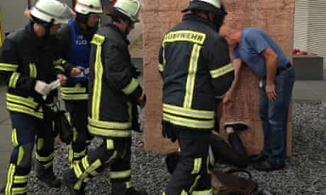 Firefighters consider how to free the student from the vagina sculpture