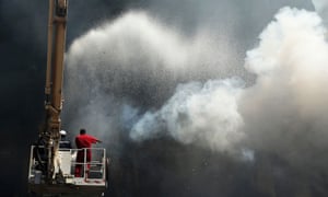 Firefighters work to extinguish a blaze at a carpet market in Benghazi reported to have started in a fireworks factory nearby
