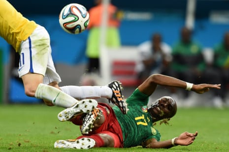 Brazil's midfielder Oscar is tackled by Mbia.