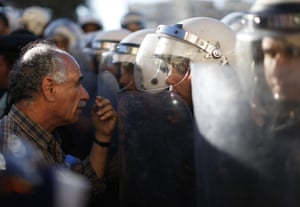A Palestinian talks to a riot policeman who, with his colleagues, blocks a street to Palestinian protesters who demonstrate against the newly cooperation between the Palestinian police with the Israeli police to find three missing Israeli teenager in the center of the West Bank town of Ramallah.
