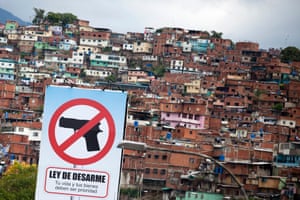 A billboard promoting a ban on guns in front of Petare, the largest slum in Caraca