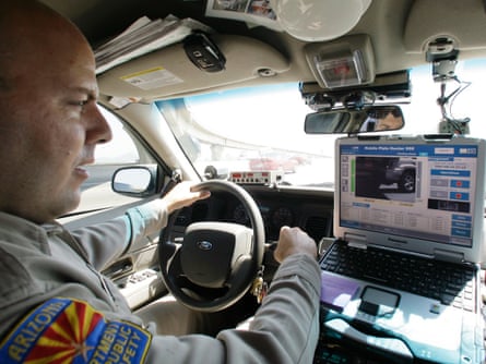 Arizona Department of Public Safety officer David Callister keeps an eye on his dashboard computer as it reads passing car licence plates.