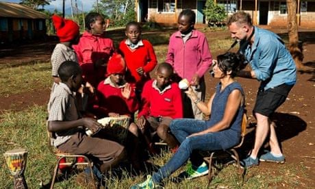Sudha Kheterpal showing percussion shaker to children in Kenya 