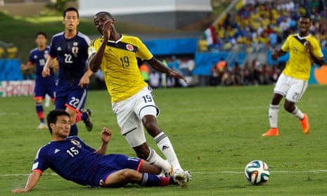 Japan's Yasuyuki Konno fouls Colombia's Adrian Ramos to give away a penalty.