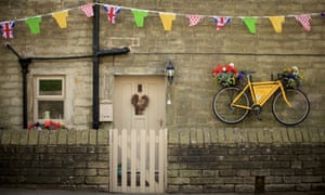A yellow bicycle hangs from the wall of a stone cottage as Yorkshire prepares to host the Tour de France Grand Depart