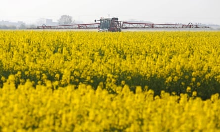 A farmer uses a crop sprayer in a field of rapeseed crops in Basildon, U.K., on April 2, 2014.