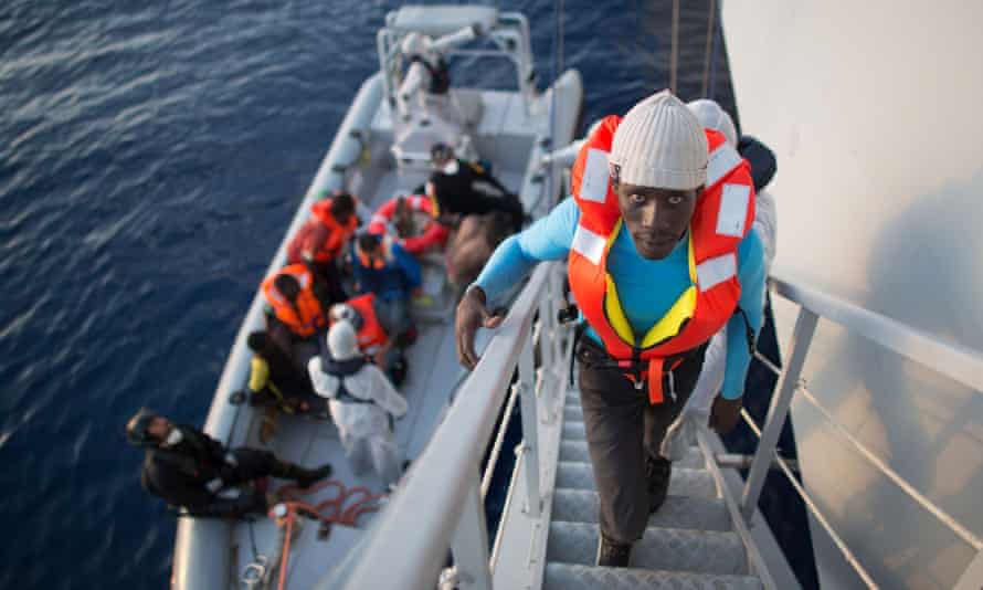 African asylum seekers rescued off boats and taken aboard an Italy navy ship.