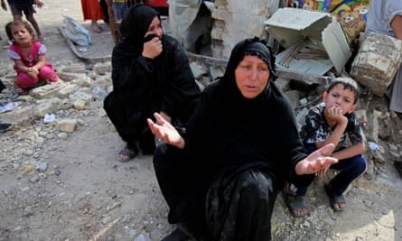 Iraqi women at a collapsed building the day after a bombing in Baghdad, Iraq, in 2010.