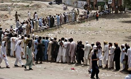 People line up to receive food supplies in Bannu, Pakistan