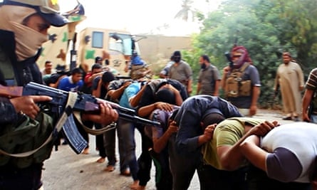 Isis miltants with Iraqi prisoners in Tikrit