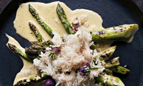 Crabmeat piled on crisscrossed asparagus spears on sauce