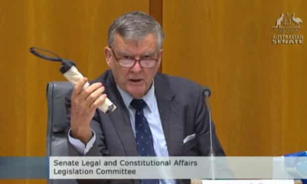 In this image made from ABC video, Sen. Bill Heffernan shows a fake pipe bomb during a committee hearing in Canberra, Australia, Sunday, May 25, 2014. Heffernan, who represents the ruling Liberal Party, was making a point about a relaxation of security at Parliament House. (AP Photo/ABC via AP Video) AUSTRALIA OUT