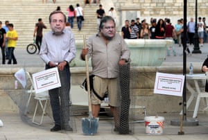 epa04241428 Greek Ecologist-Greens activists who wear masks depicting Greek Prime Minister Antonis Samaras (L) and Vice President Evangelos Venizelos (R) staged a happening in front of the Greek Parliament in Athens, Greece last week.