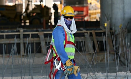Worker in yellow helmet and dark glasses on construction site