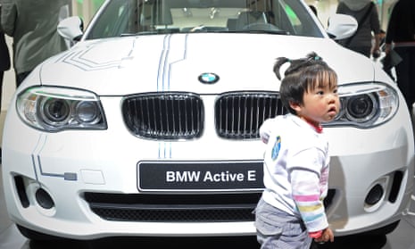 A Chinese child looks on next to the Active-E , an electric car made by German car manufacturer BMW, at the Shanghai Auto Show in Shanghai