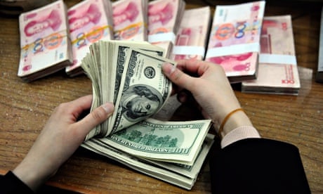 A bank clerk counts yuan and dollar bills, in China