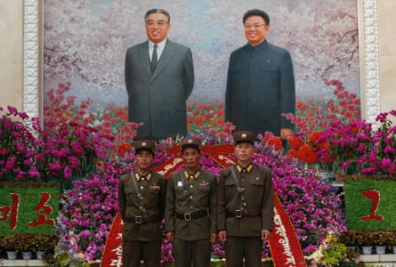 North Korean soldiers pose for a picture in front of portraits of the late leaders Kim Il-sung and Kim Jong-il in Pyongyang.