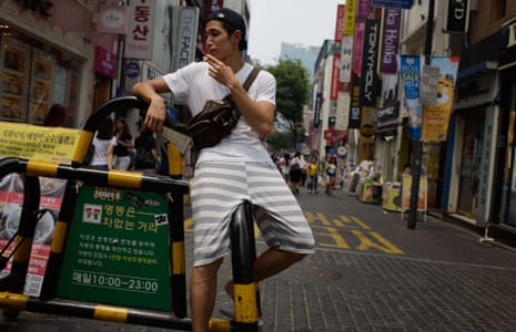 A local man pauses for a cigarette in the Myeongdong shopping district of Seoul.