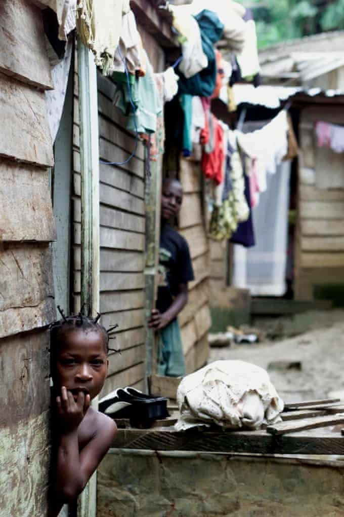 A young girl leans out of the doorway of her house in a slum neighbourhood of Malabo, capital of Equatorial Guinea, in 2002. (AP Photo/Christine Nesbitt)