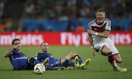 Bastian Schweinsteiger goes down under the double challenge of Lucas Biglia and Argentina's midfielder Javier Mascherano.