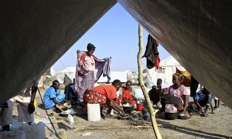 South Sudanese refugees cook on an open fire at a camp