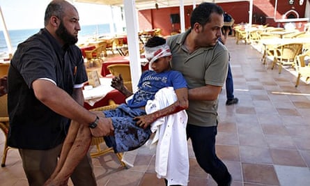 Palestinian al-Deira hotel employees carry a wounded boy - gaza port shelling