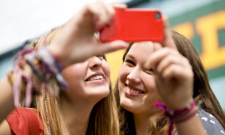 Two teenage girls taking a photograph of themselves.
