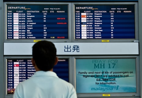 A Malaysian man looks at flight information screens displaying a solidarity message for Malaysia Airlines flight MH17 at Kuala Lumpur International Airport in Sepang on July 18, 2014.