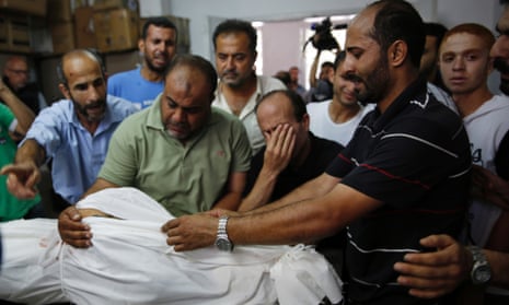 Relatives gather at a hospital morgue around the body of a member of the Abu Tawela family killed overnight by an Israeli strike.