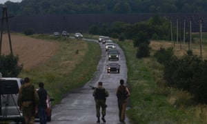 Pro-Russian separatists watch as OSCE monitors arrive at the crash site of Malaysia Airlines flight MH17, near the settlement of Grabovo ukraine