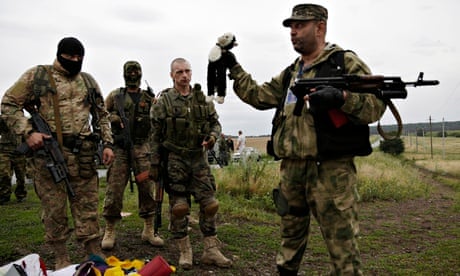 A pro-Russia fighter holds up a toy found among the debris at the crash site of MH17
