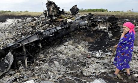 A resident surveys the wreckage at the Flight MH17 crash site in Ukraine.