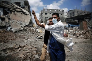 A medic comforts a Palestinian in the Shejaia neighbourhood in Gaza City, which was heavily shelled by Israel.