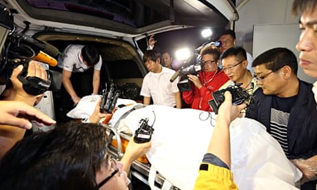 Policemen transport a stretcher with a body believed to be that of Yoo Byung-un