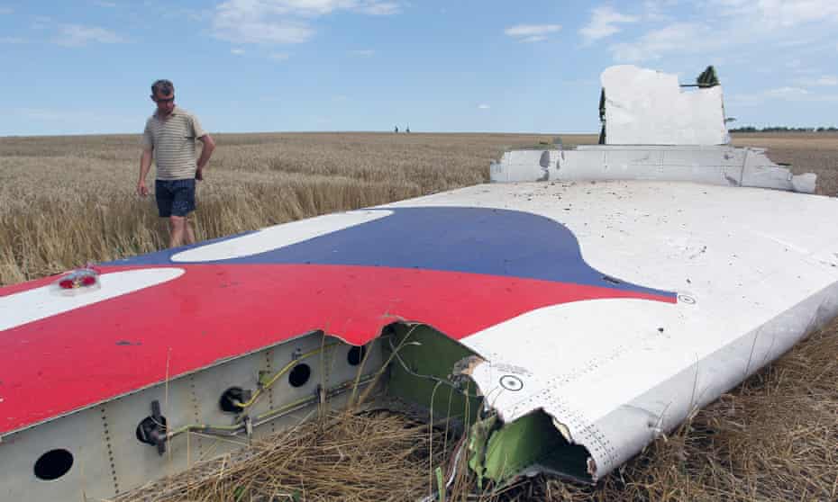 A man inspects debris at the main crash site of Malaysia Airlines flight MH17