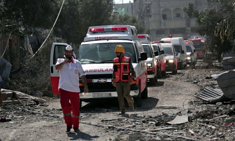 A Palestinian rescue convoy navigates rubble in Gaza City