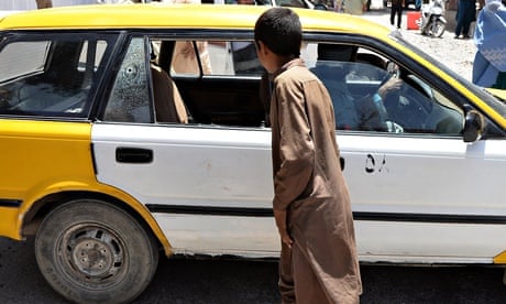 A youth looks at the taxi in which two Finnish women were shot in Herat, Afghanistan.