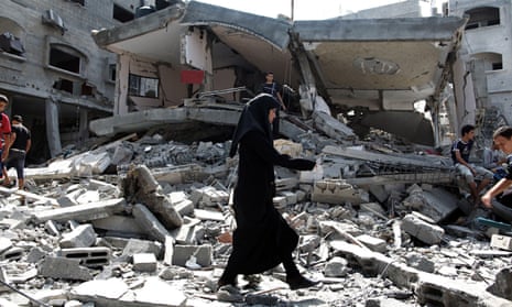 A woman walks on debris in Gaza
