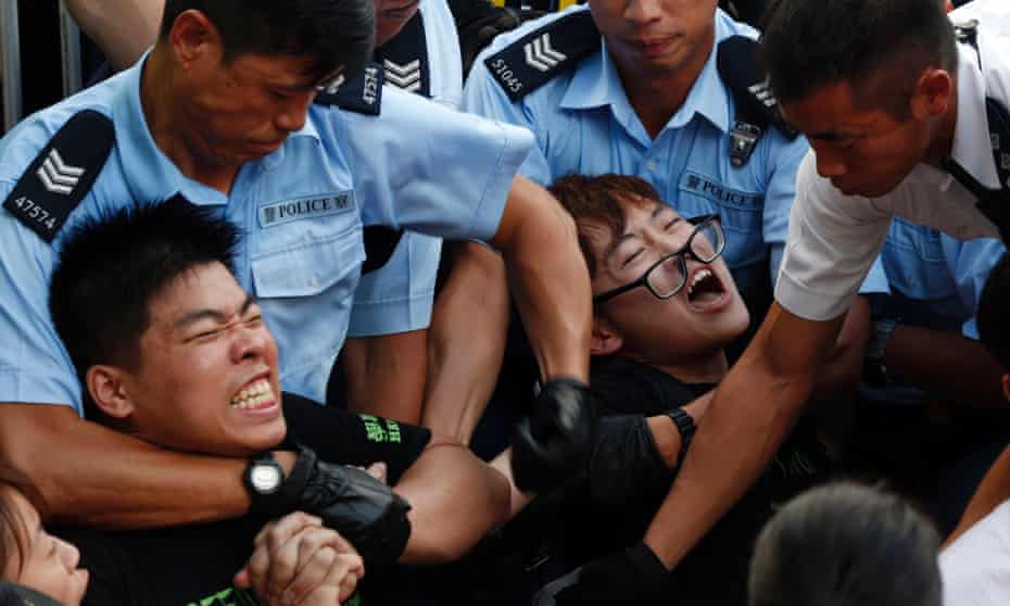Protesters are taken away by police officers after hundreds of protesters staged a peaceful sit-ins.