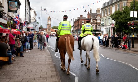 Mounted police on horses patrolling the street, Newmarket town Suffolk UK