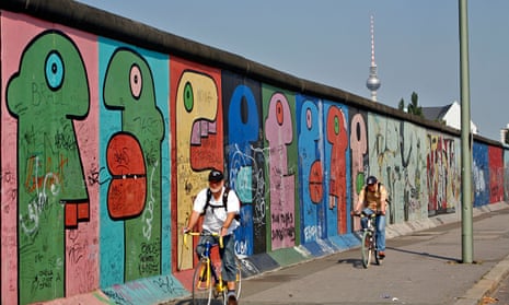Cyclists ride along Berlin Wall
