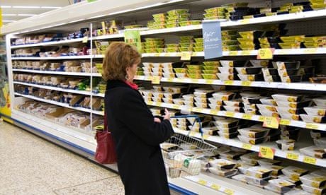 Woman in the ready meal aisle of Tesco Extra supermarket England UK