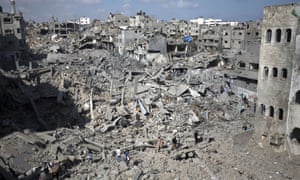 Palestinians walk across the rubble of destroyed buildings and homes in the Shejaiya residential district of Gaza City.