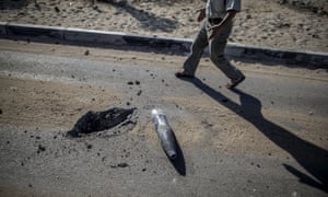 A Palestinian man walks past a unexploded tank shell while walking back towards the northern district of Beit Hanun in the Gaza Strip.
