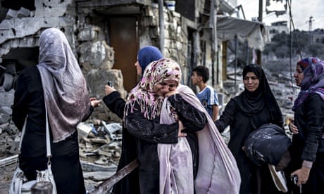 Palestinian women react to the destruction in Beit Hanuon, northern Gaza Strip, during the ceasefire