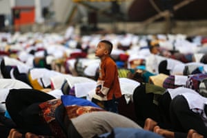 Jakarta, Indonesia: A boy watches a remote-controlled camera fly above during a prayer session at Sunda Kelapa port.